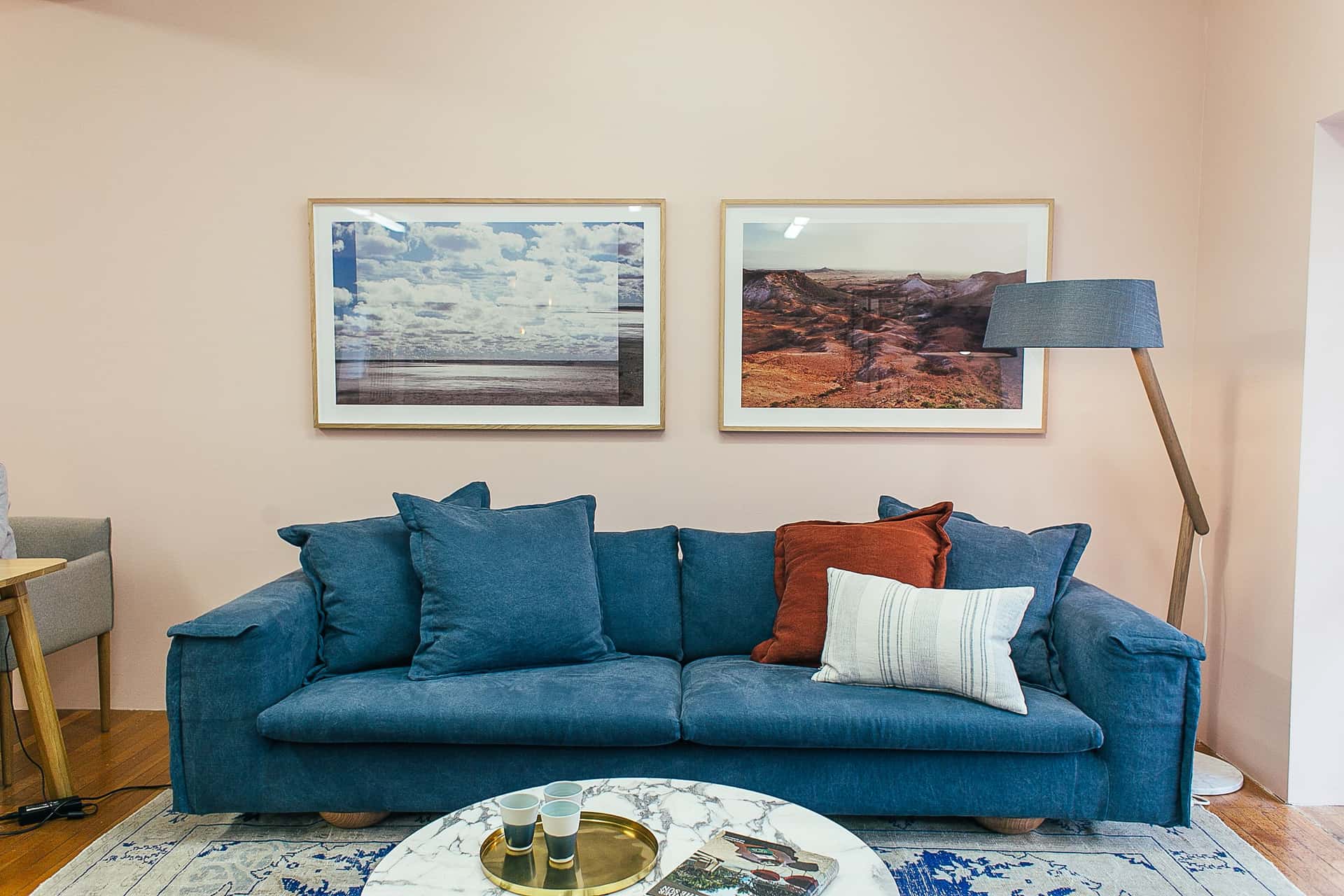 A wide framed print centered above a sofa