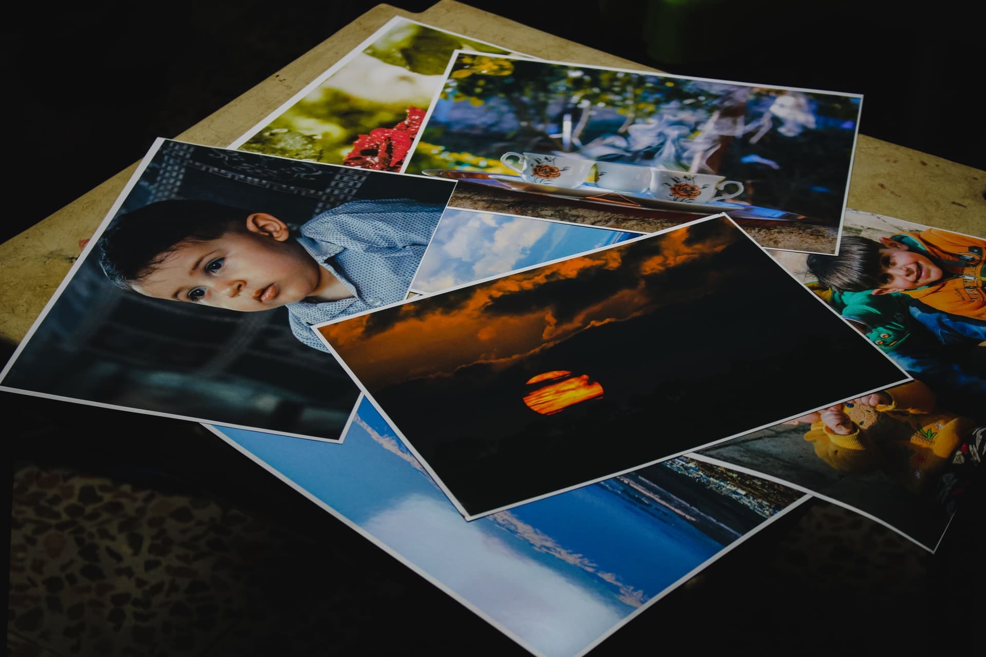 Unframed art prints fanned out on a table beside a frame