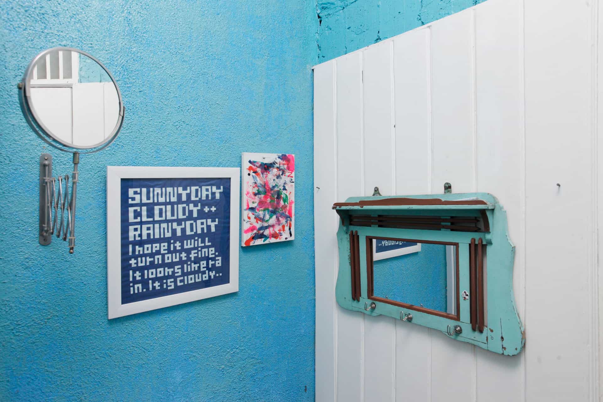 A small framed print on a tiled bathroom wall