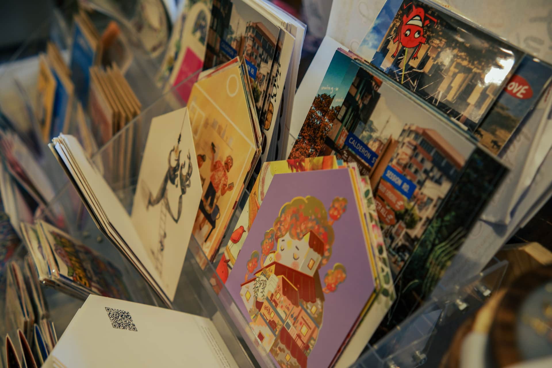 Art prints displayed in a browser rack at a gallery shop