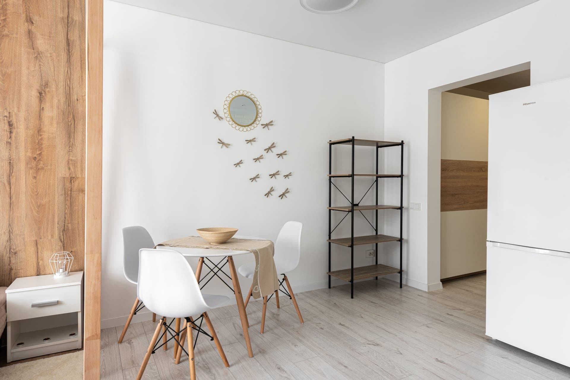A framed print on a dining room wall beside a set table