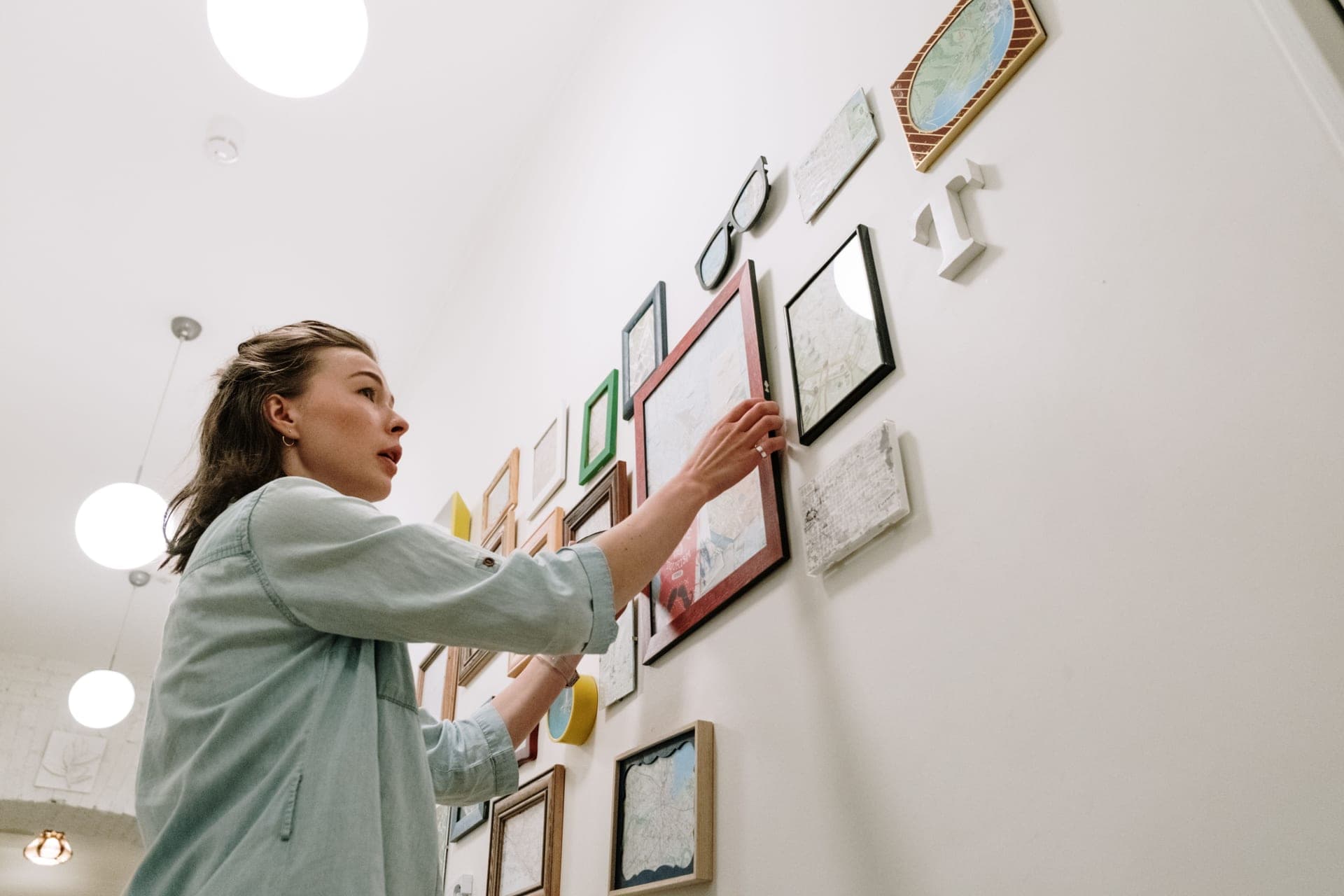 Framed prints being positioned on a wall with paper templates taped up
