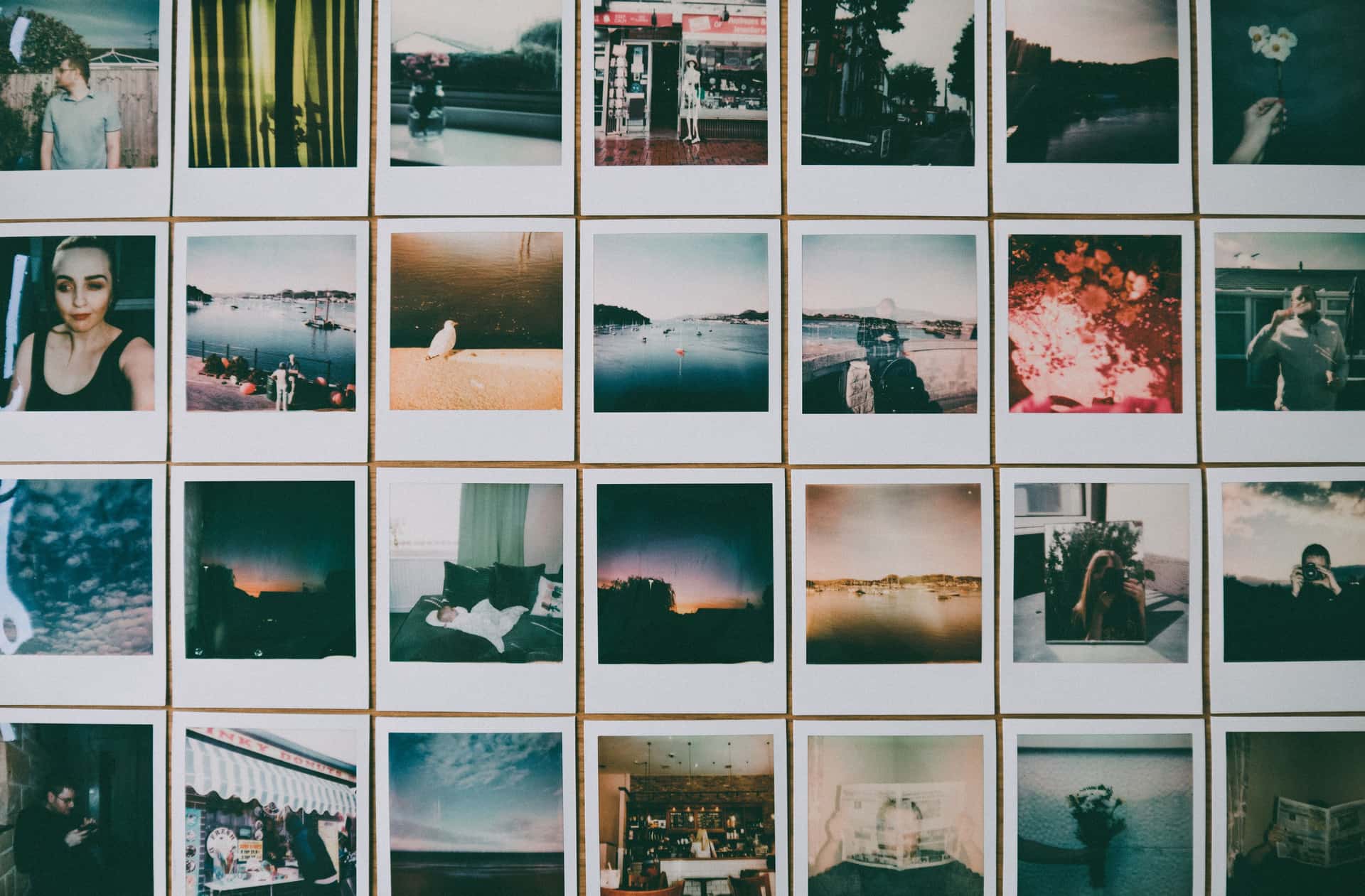 A grid of matching framed prints arranged evenly on a pale wall