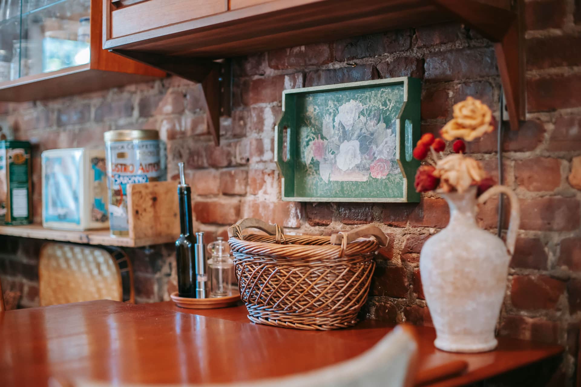 A small framed print on a kitchen wall beside open shelving