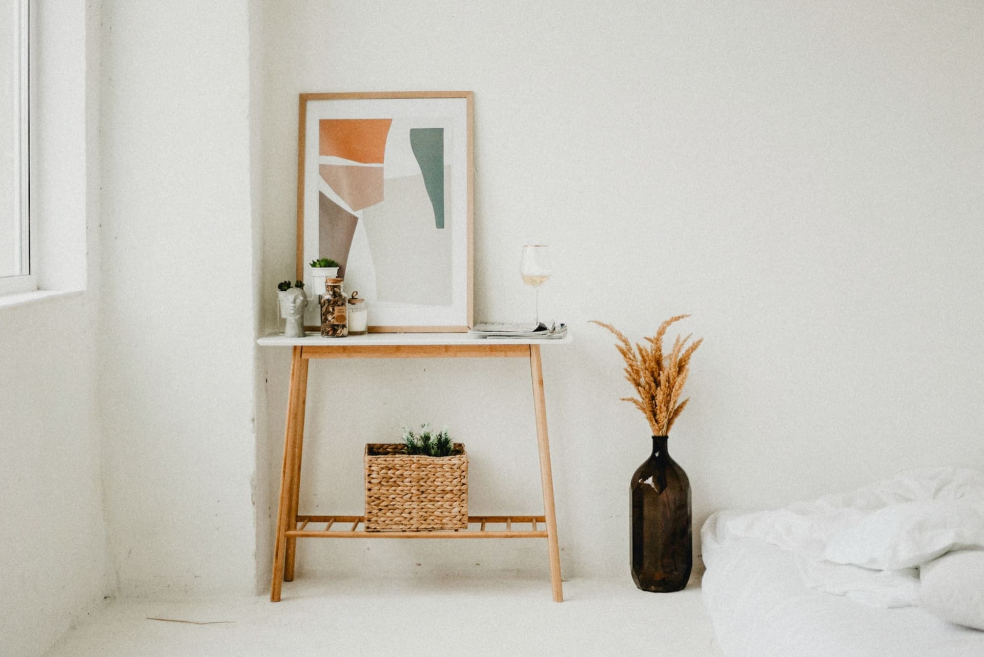 A muted abstract print above a neutral sofa in a calm room