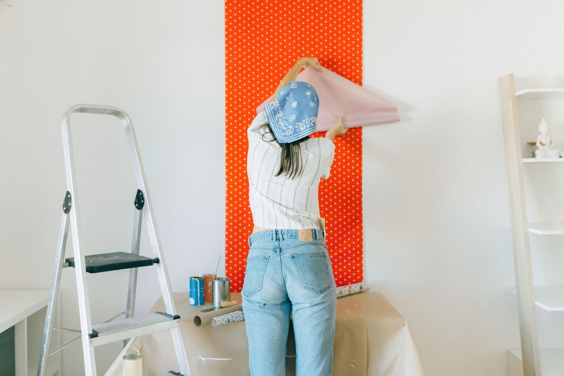 A peel-and-stick decorative panel being smoothed onto a wall