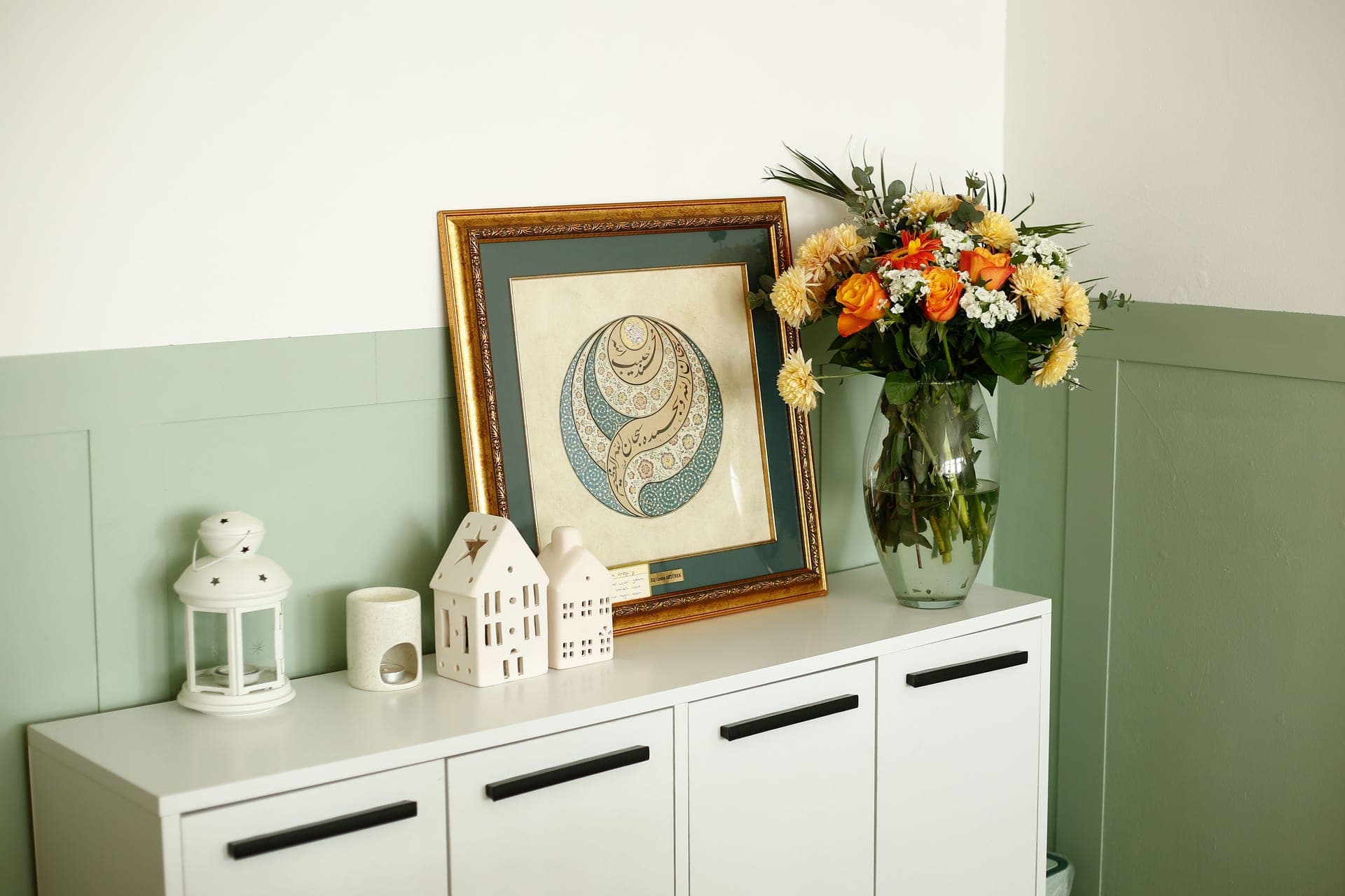 Framed photographs arranged on a sideboard beside a small gift box