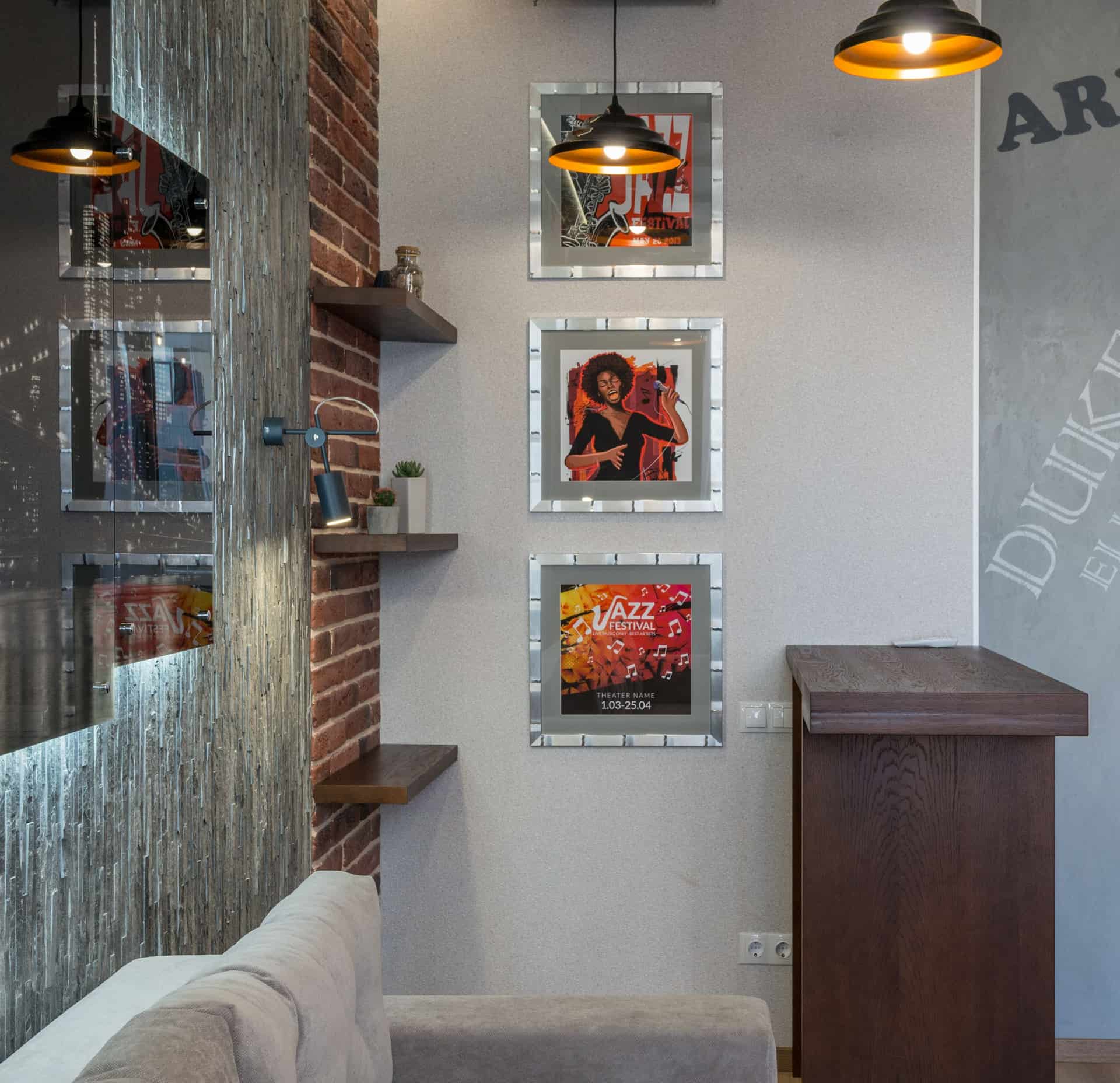 Framed prints leaning on a narrow wall-mounted ledge above a sofa