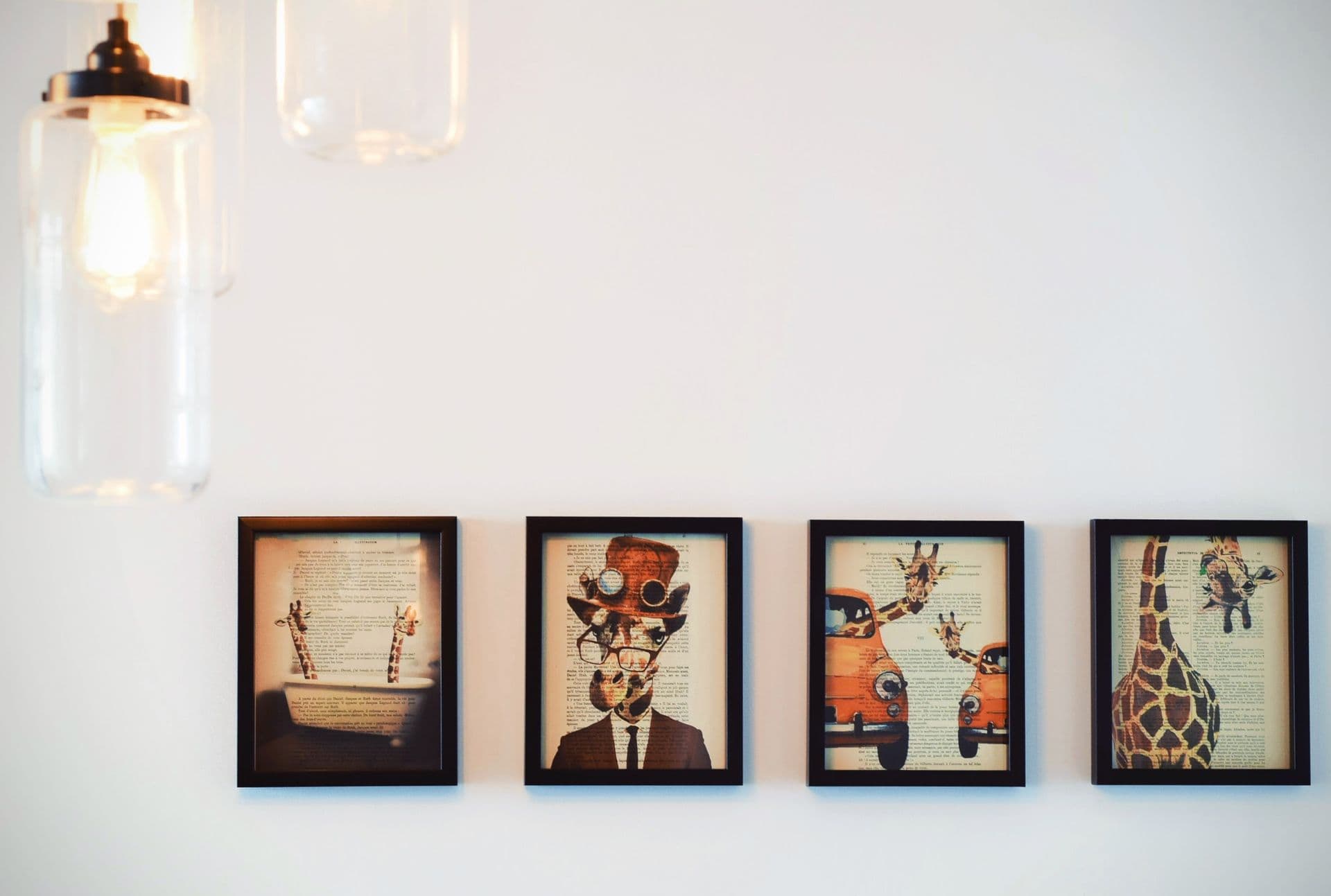 Four matching framed prints hung in an evenly spaced row on a warm-lit wall