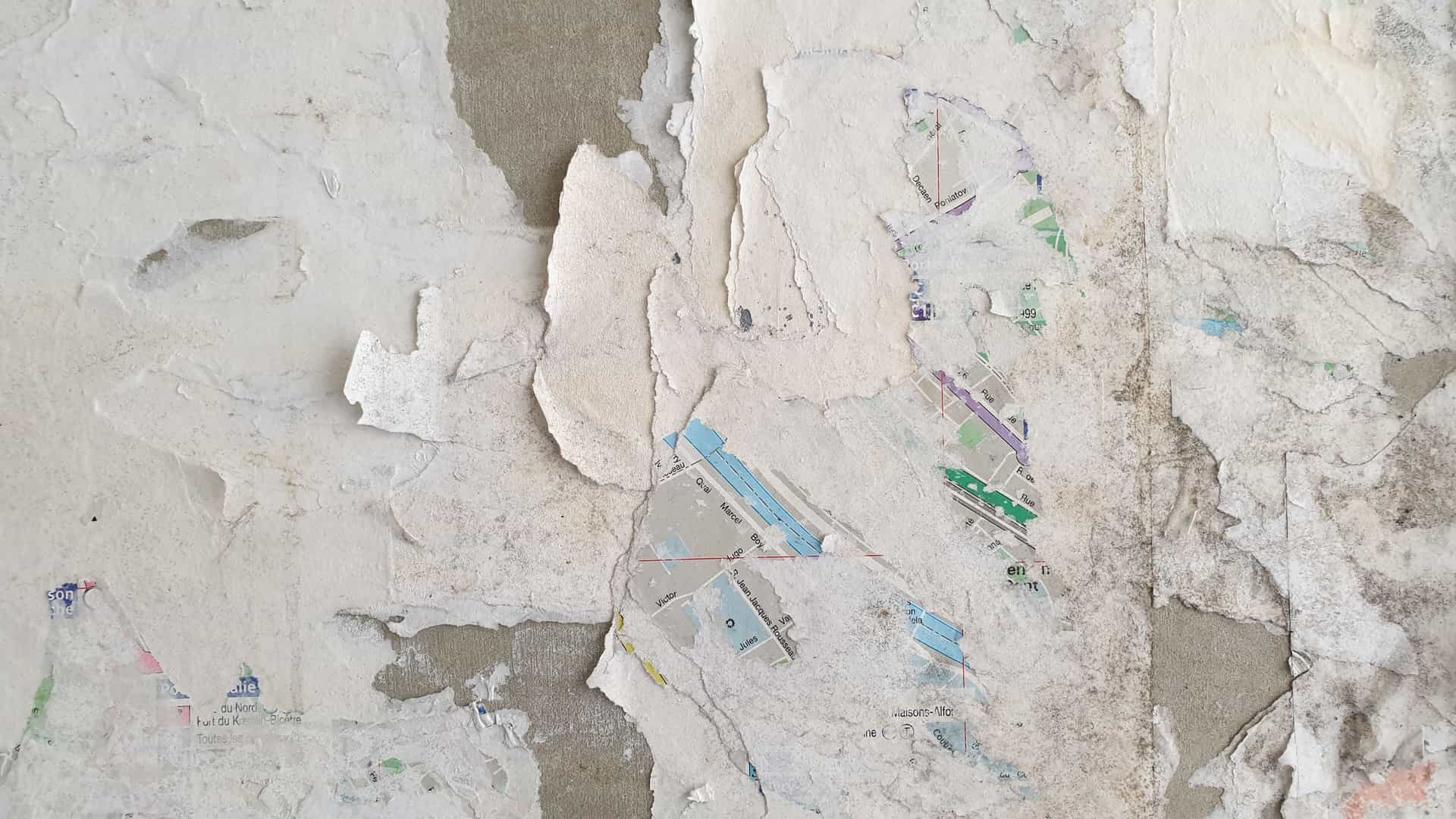A peel-and-stick decorative wall panel being smoothed onto a wall