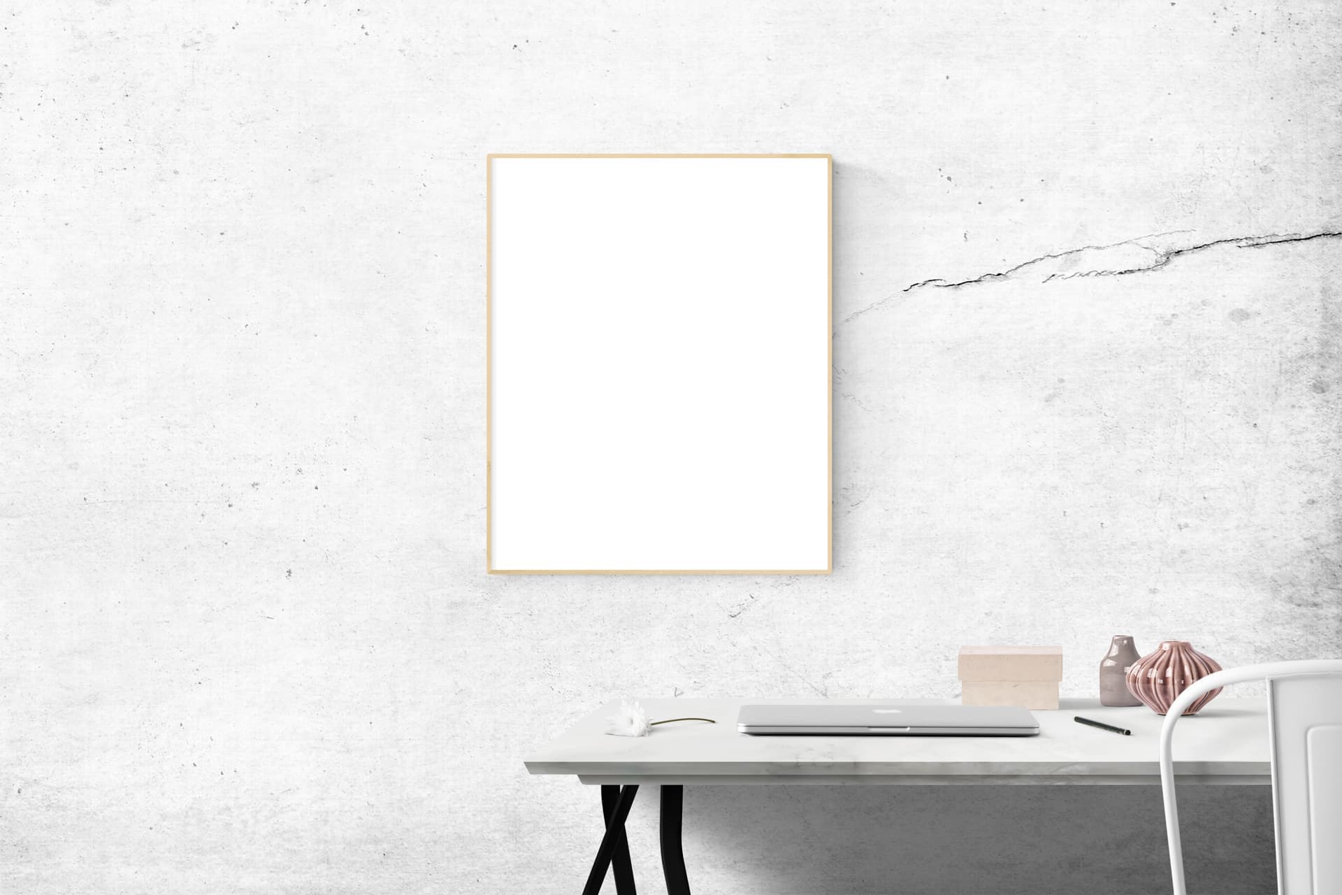 A large black poster frame hanging on a plain wall in a bright room