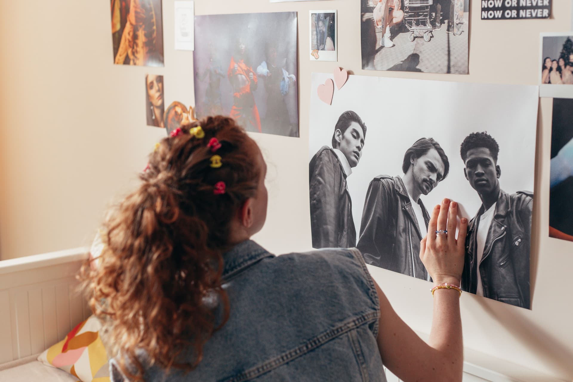 An unframed paper poster mounted flat against a pale painted wall